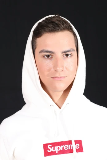 a man in a white hooded sweatshirt with the supreme on it