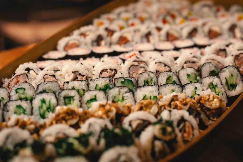 a wooden platter filled with lots of sushi
