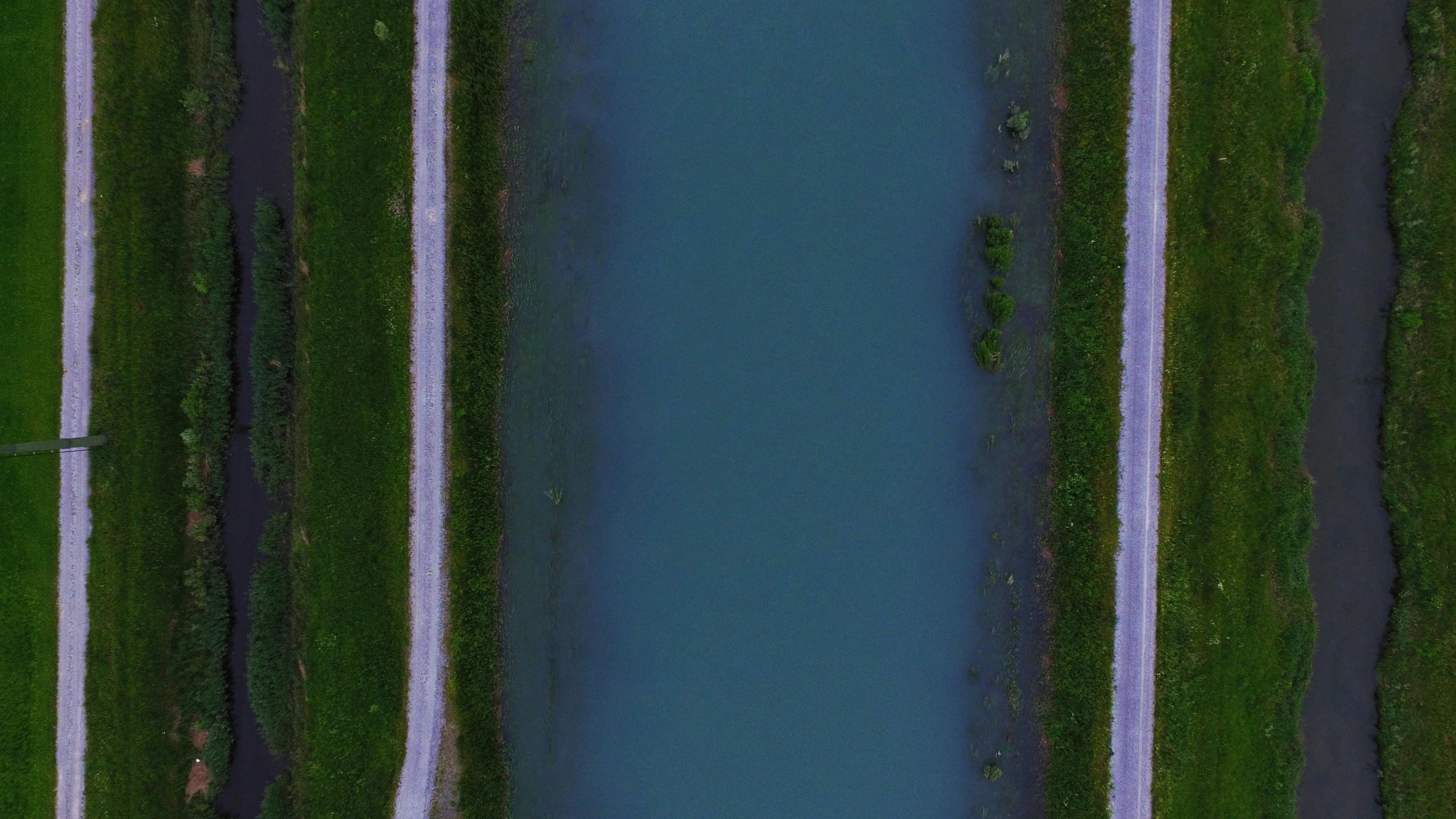 a bird's eye view shows a river between some roads