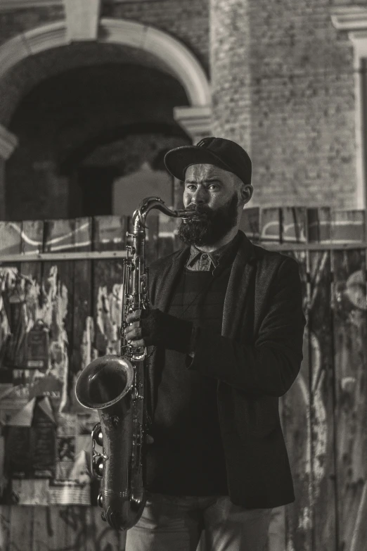 a man standing on the street holding onto a saxophone