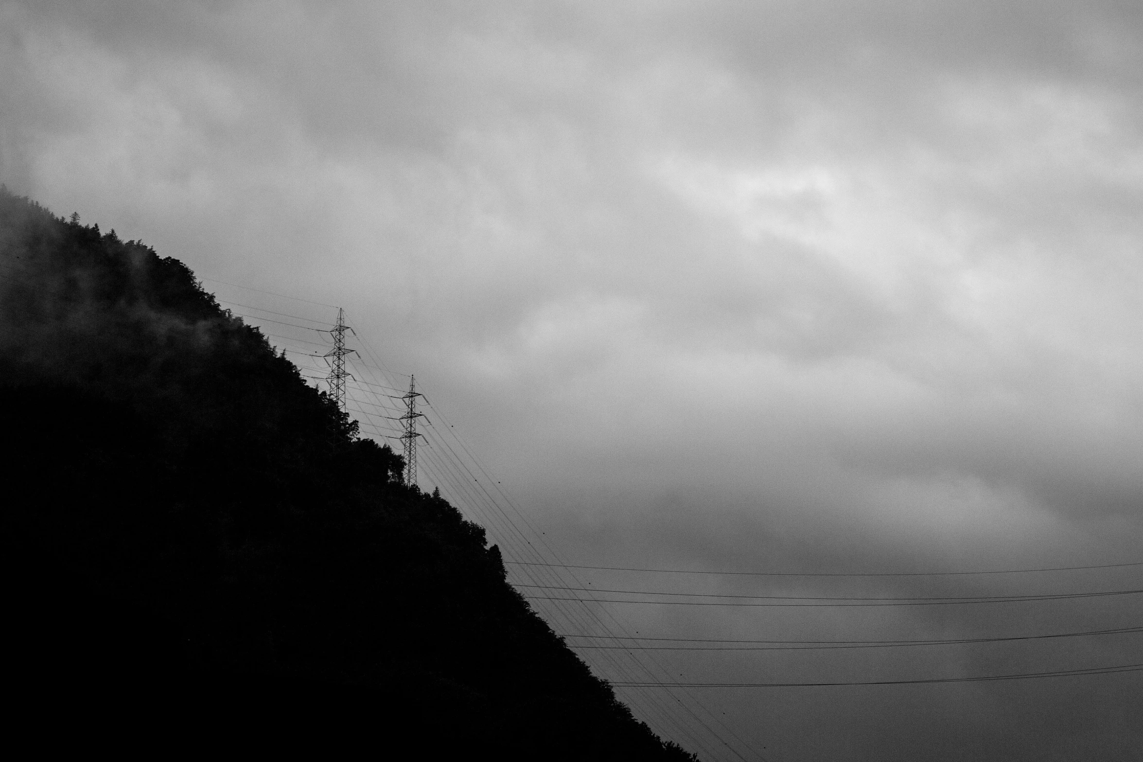 a large hill sitting with power lines below it