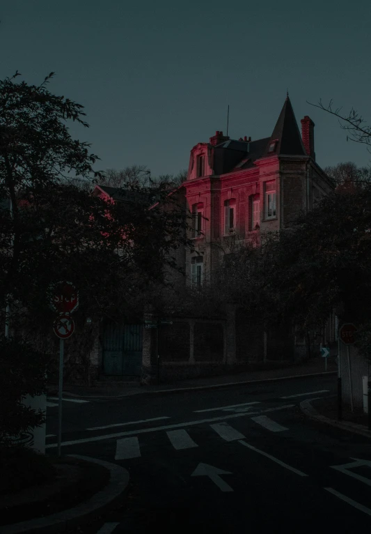 a red building with dark trees behind it