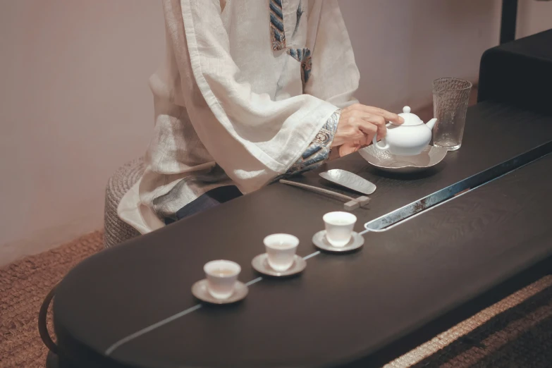 a woman is getting ready to put a tea cup on a table