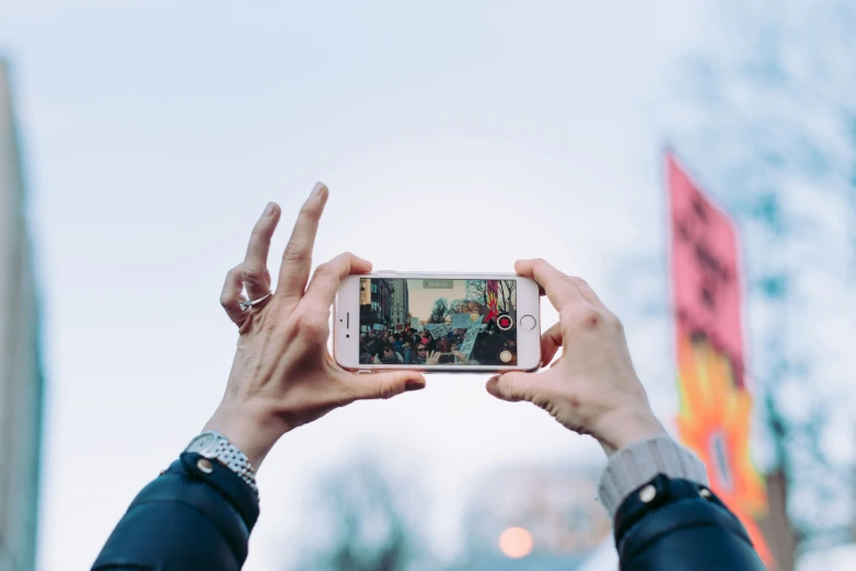 two hands are holding up a smartphone to take pictures