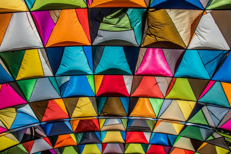 many colorful umbrellas are on display inside a building