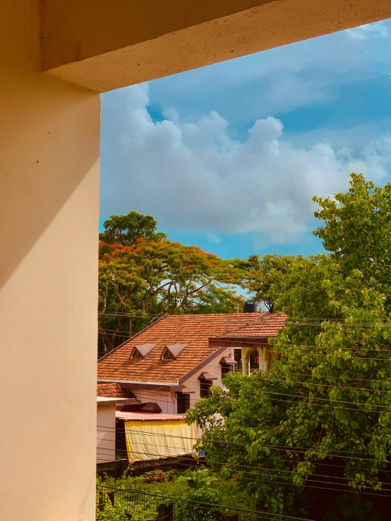 some buildings and trees with a cloudy sky in the background