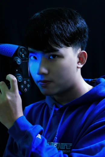 a man in a blue hoodie holding a game controller