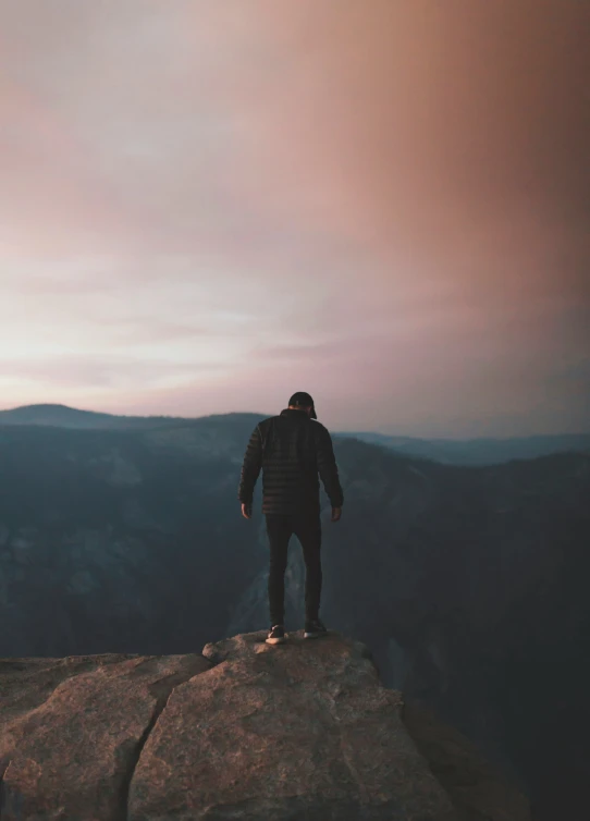 the person on the top of a mountain is looking into the distance