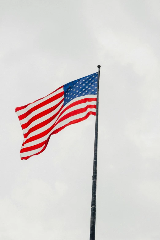 a large american flag flying high in the sky