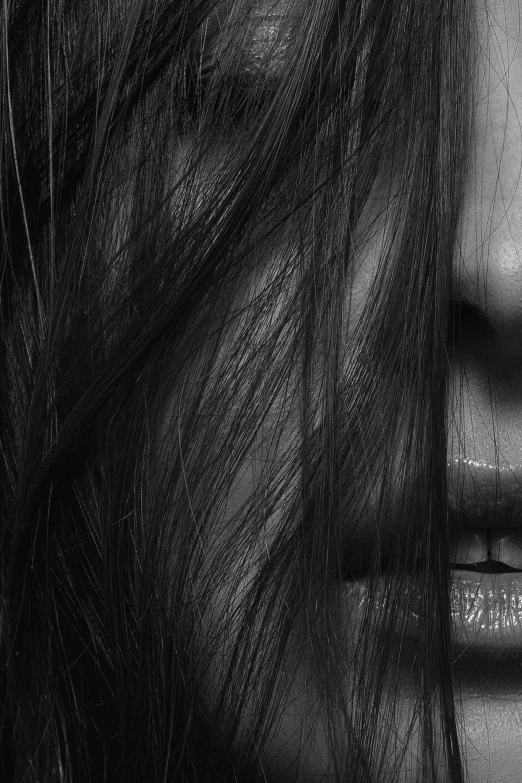 black and white pograph of woman's head with hair blown in the wind