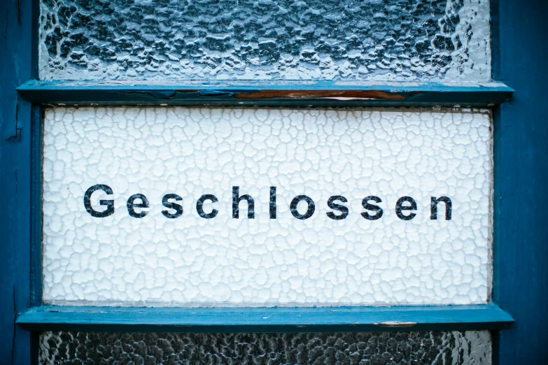 a close up s of a glass window with the word geschlosen written in black