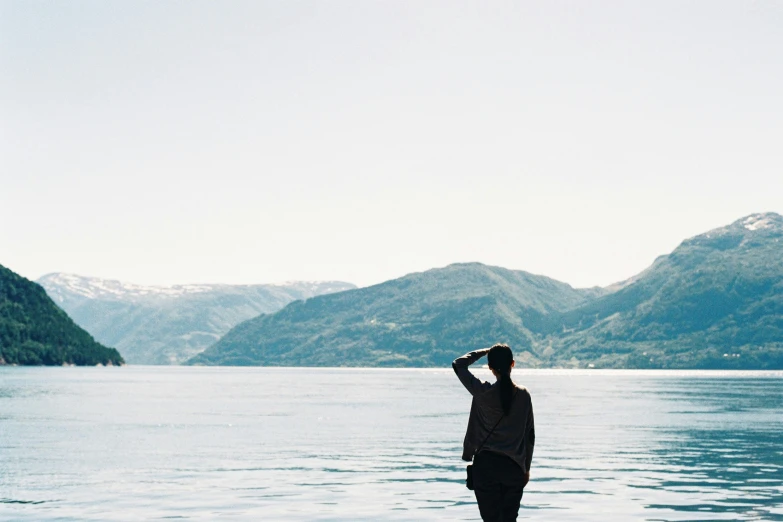 a person standing on top of a rock by the water