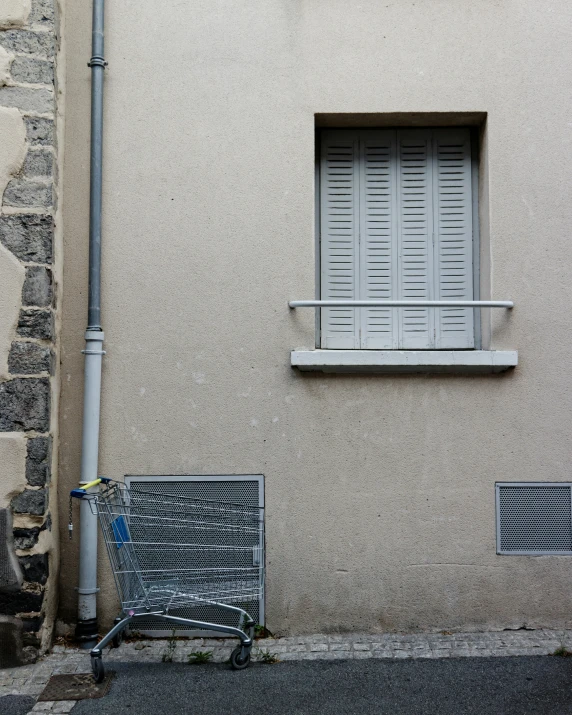 an empty shopping cart sits outside of a building