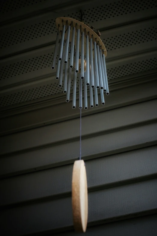 a small wooden object suspended from a black string