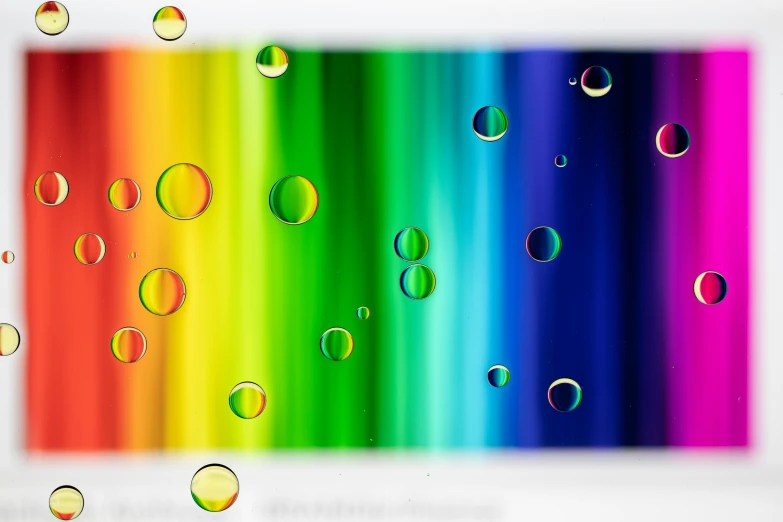 some bubbles that are on the side of a rainbow - colored wall