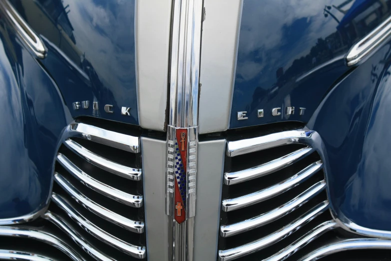 close up po of the emblem and front grille on a blue car