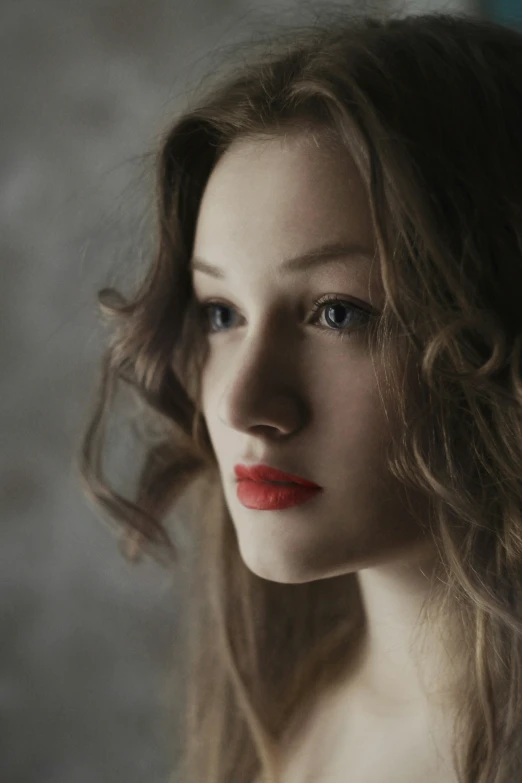 a woman with long wavy hair is looking ahead