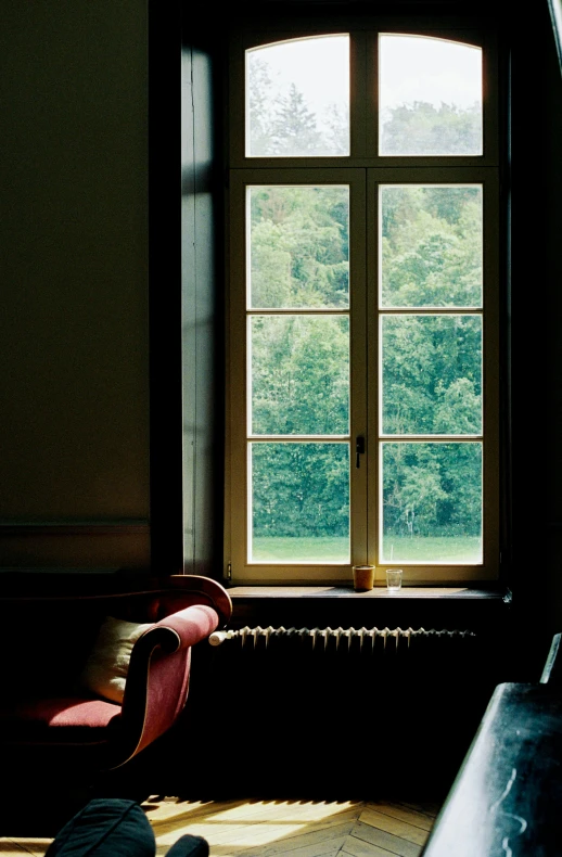 a room with large windows and a chair next to the window