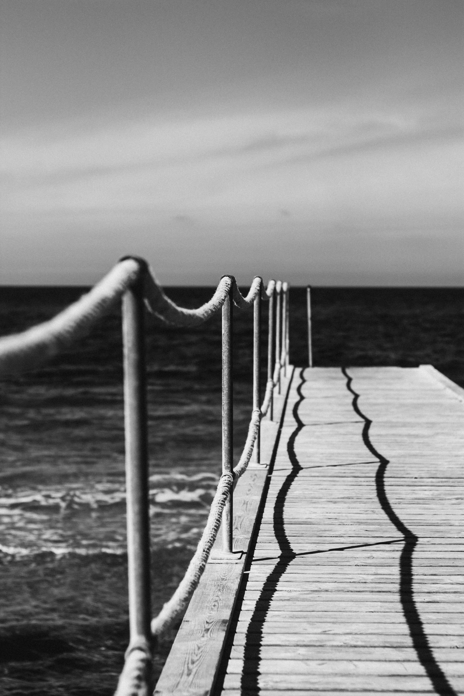 a long dock that is leading to the ocean