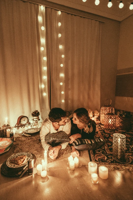 two people sitting in front of a candle