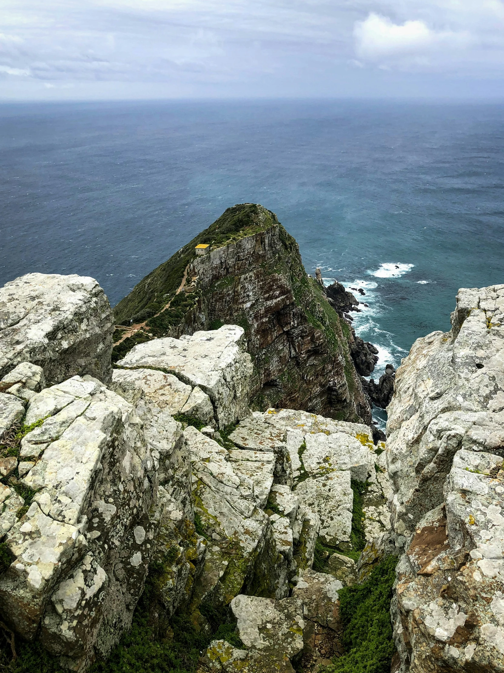 a couple of rocks on a cliff near the ocean