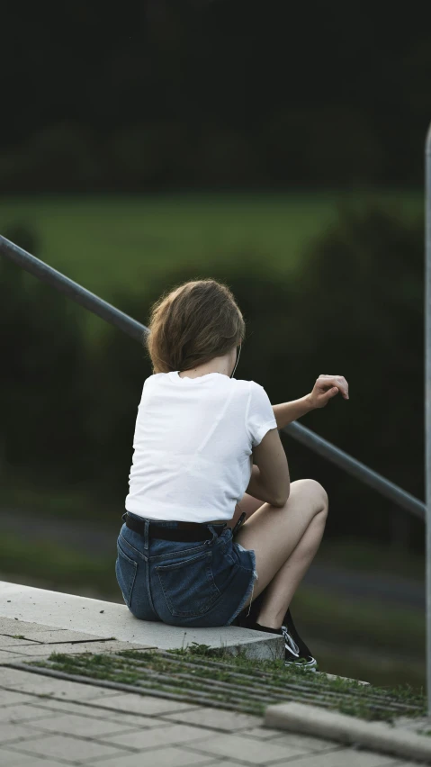 a boy sitting on the ledge of a roof
