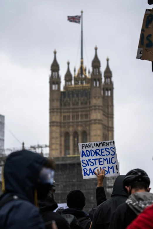 a group of protesters with a sign protesting against racism