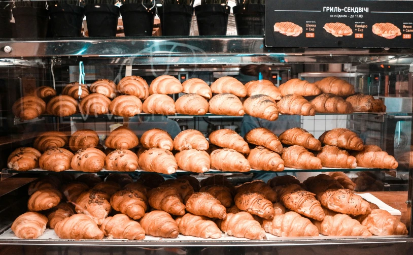 various types of bread are displayed in a bakery