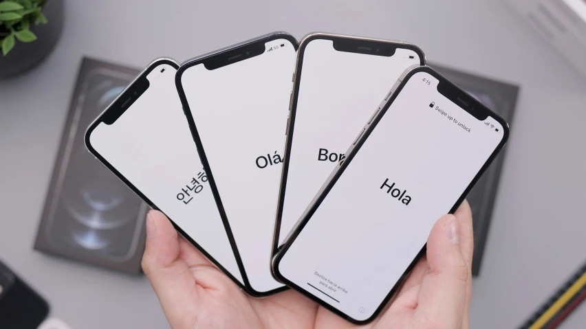 three iphones in different styles in someone's hand