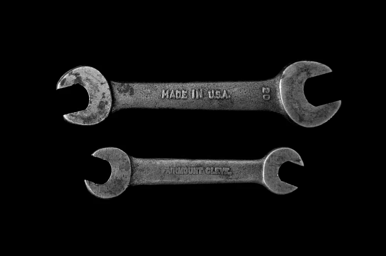 two wrenches with one and a half crossed on the inside