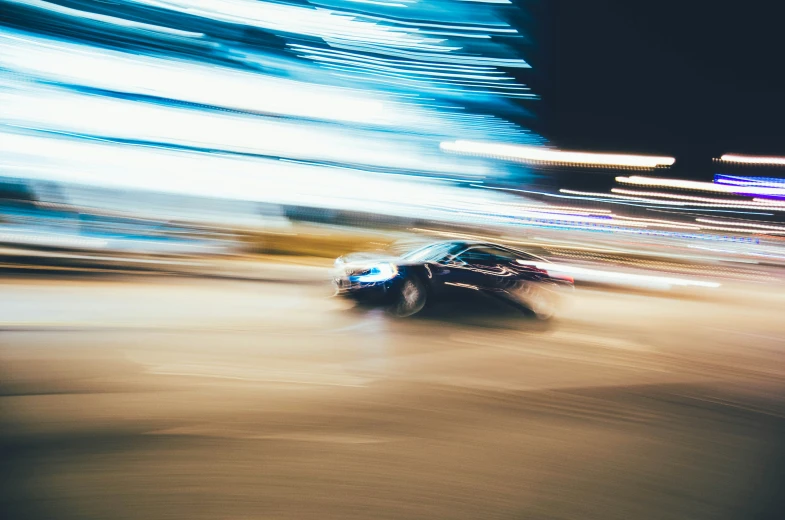 a car speeds through a city street at night