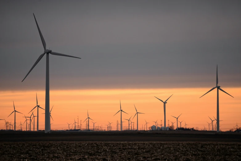 a group of windmills sitting on top of a dry grass field