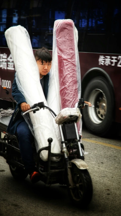 a  on a motorcycle holding blankets