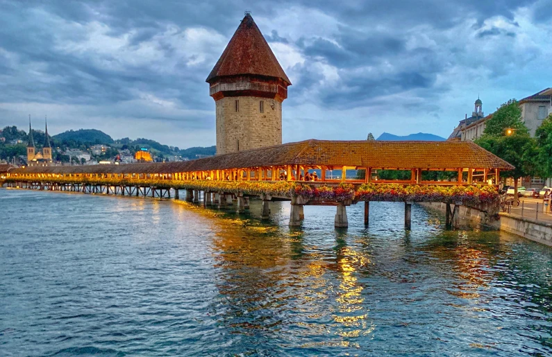 the clock tower is near the bridge that goes across the water