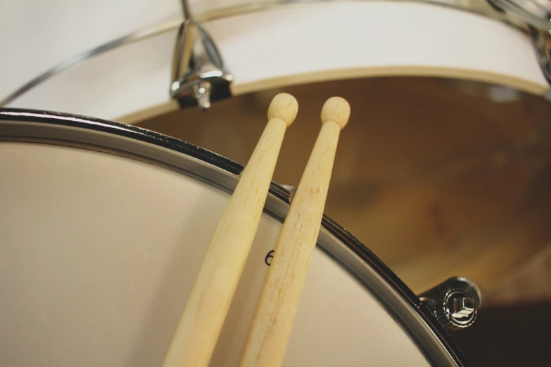 two sticks stuck between two drum heads in a drum set