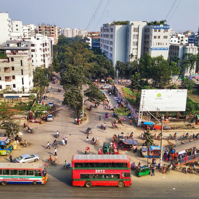 buses traveling down the road near buildings