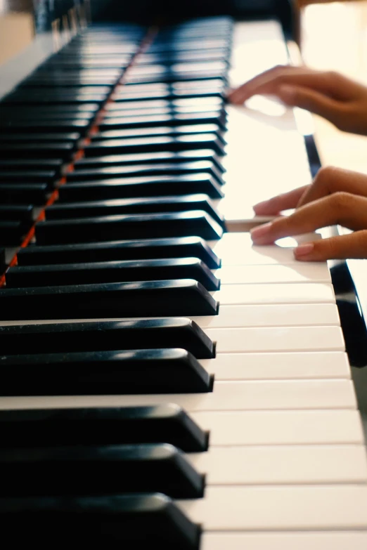 a close up image of some hands on the piano keys