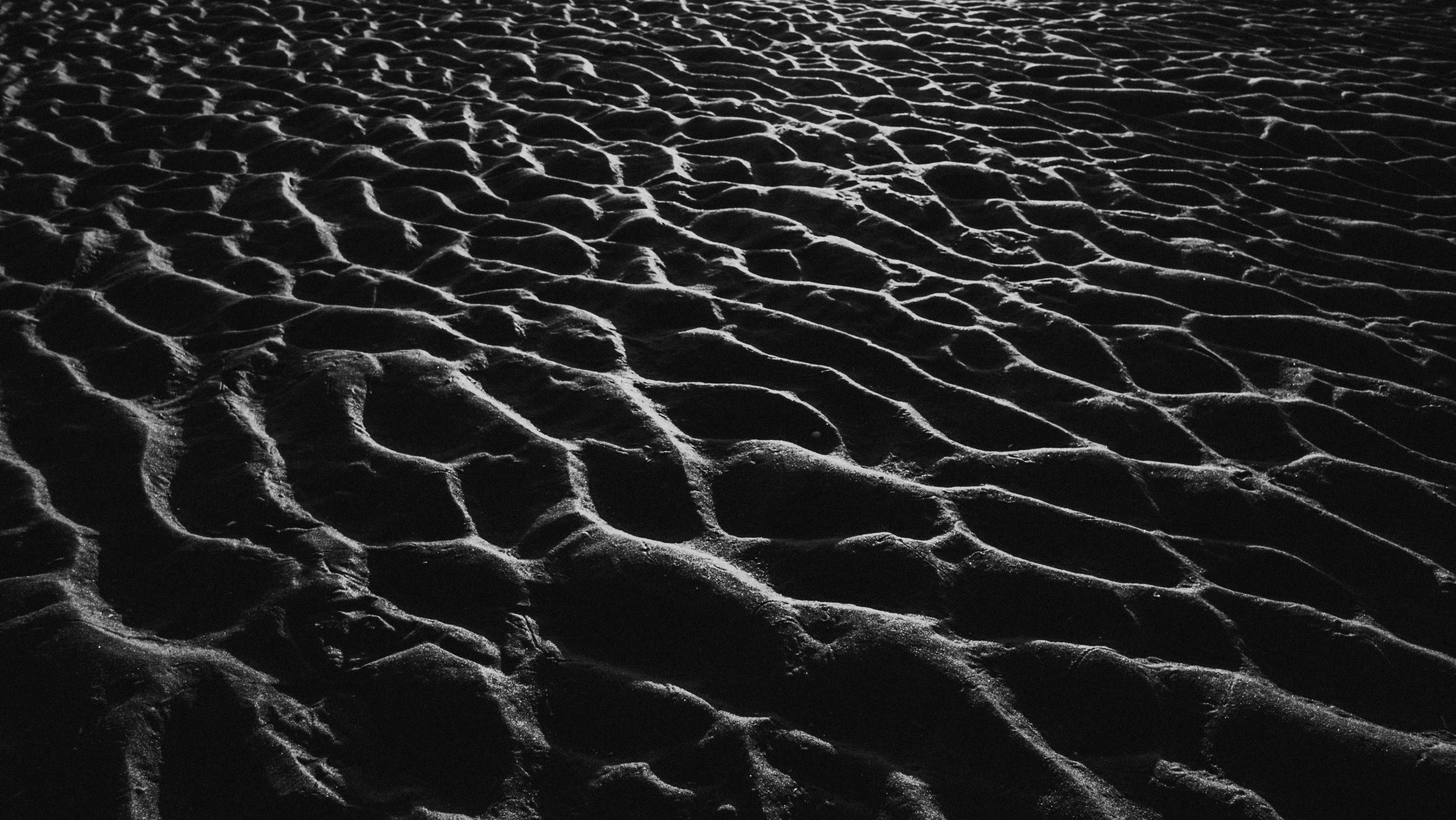 black and white pograph of beach sand at dusk