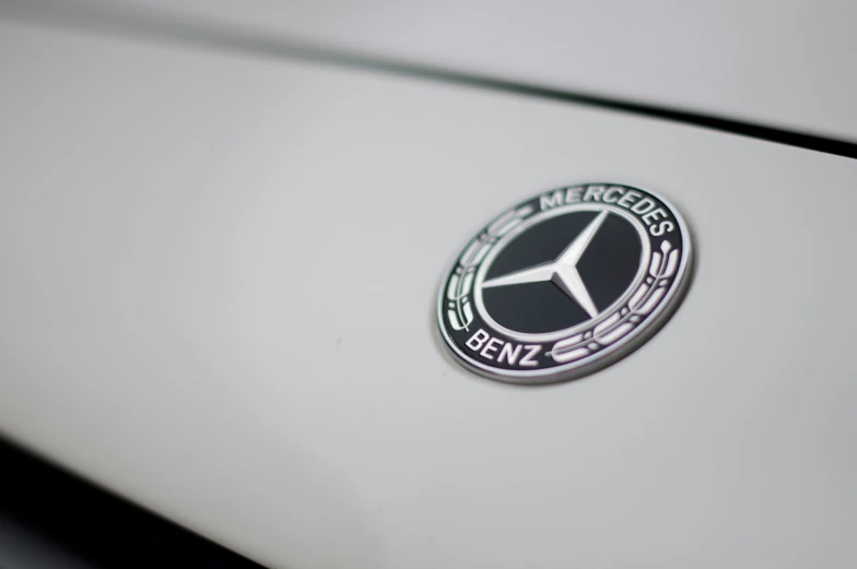 the mercedes benz badge on a white car