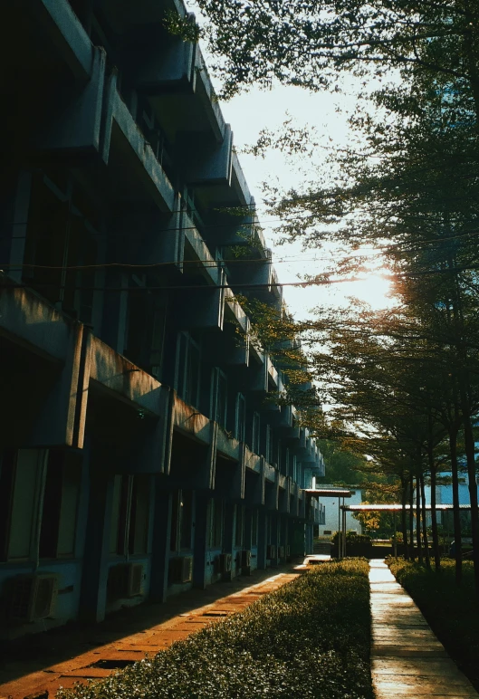 a walkway next to a row of flats in front of some tall buildings