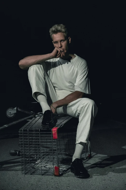 a man sits on the back of a wire cage