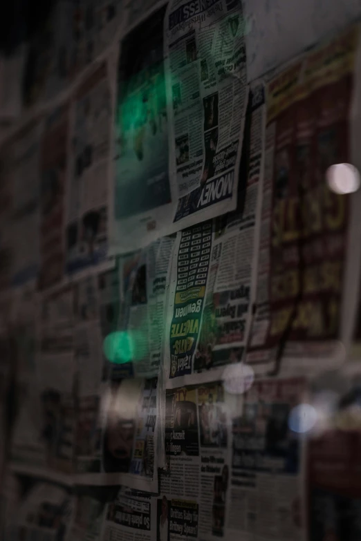 a glass window reflecting newspapers and green light