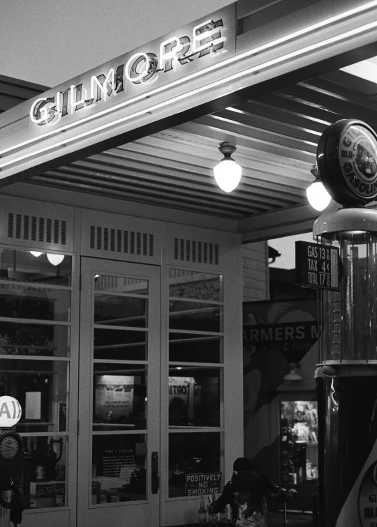 black and white image of a store front with lights on