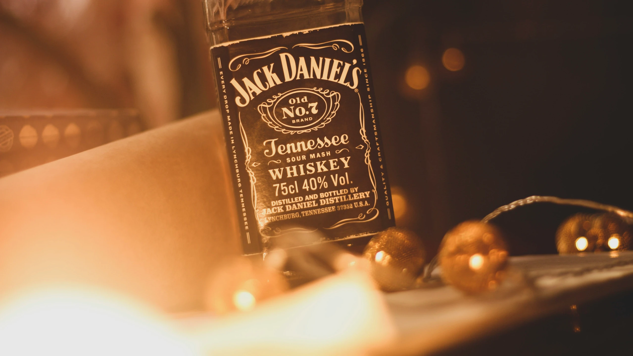 a bottle and candle on a counter with many candles