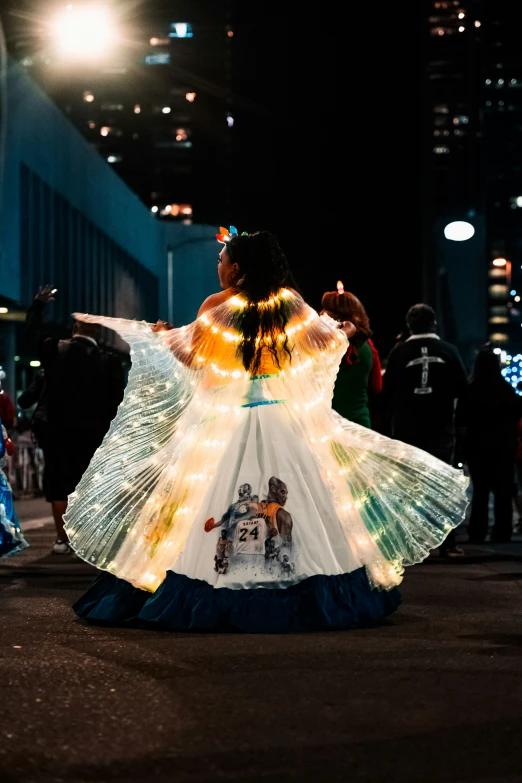 a woman with an umbrella wearing dress under the lights of the night