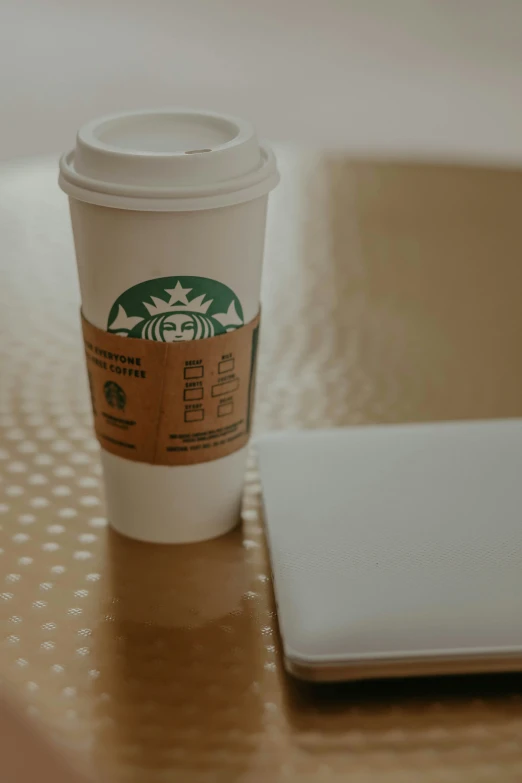 there is a coffee cup next to a laptop