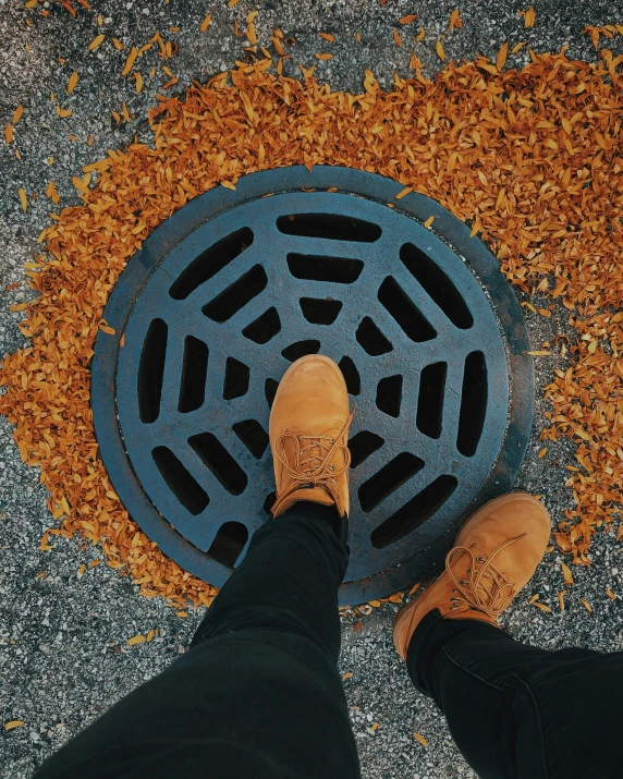 the feet are standing in front of the black drain