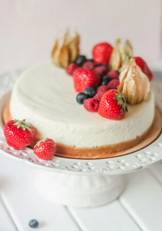 a fancy layer cake with fresh fruit on top