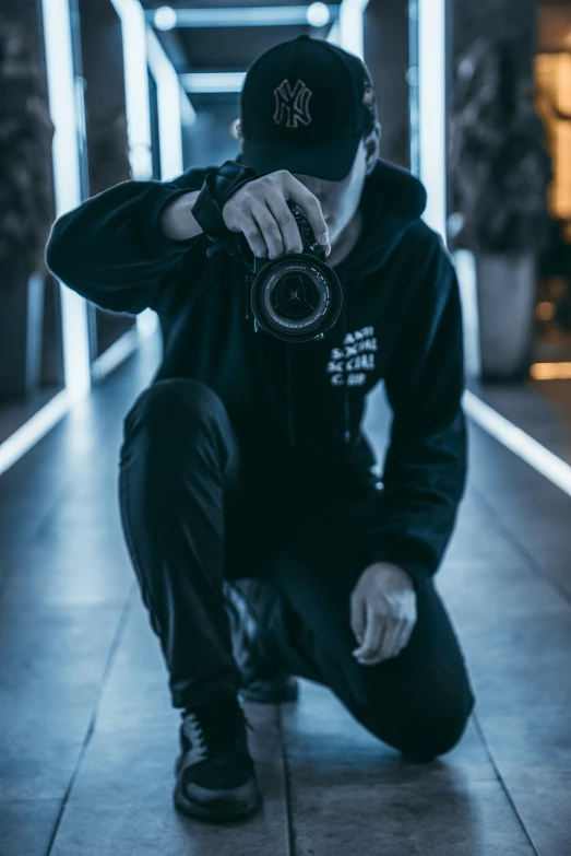 a man kneeling down with a camera in his hand