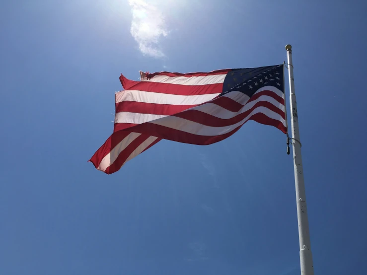 an american flag waving against a blue sky